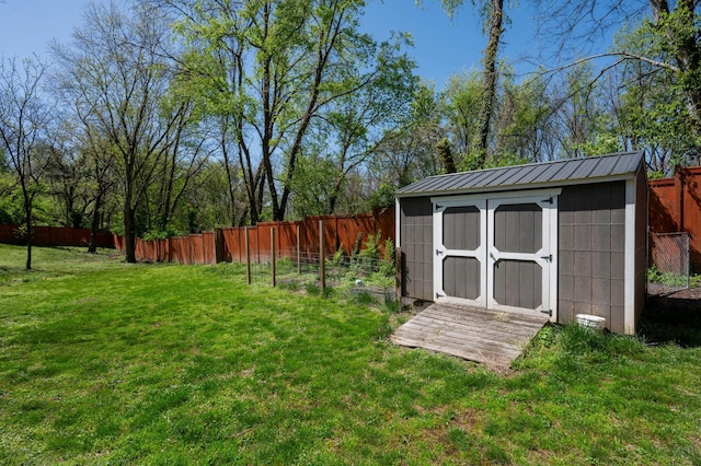 view of yard with a storage shed, a fenced backyard, and an outdoor structure