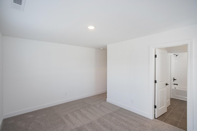 carpeted spare room featuring recessed lighting, baseboards, and visible vents