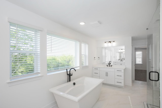 bathroom featuring vanity, marble finish floor, baseboards, a freestanding bath, and a stall shower
