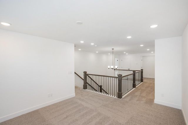 empty room featuring baseboards, light carpet, and recessed lighting