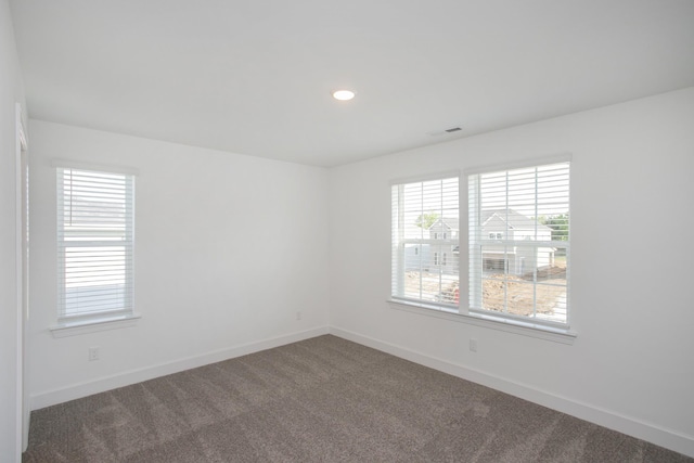 carpeted empty room featuring plenty of natural light, recessed lighting, baseboards, and visible vents