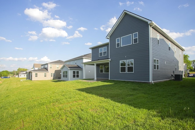 back of property featuring a lawn and cooling unit