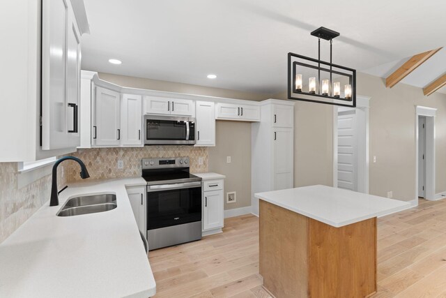 6149 Dewey Carr Rd, Bethpage, TN 37022 - kitchen with stainless steel appliances, backsplash, white cabinetry, light wood-type flooring, and a center island