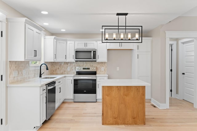 6149 Dewey Carr Rd, Bethpage, TN 37022 - kitchen featuring stainless steel appliances, light wood finished floors, light countertops, a center island, and decorative backsplash