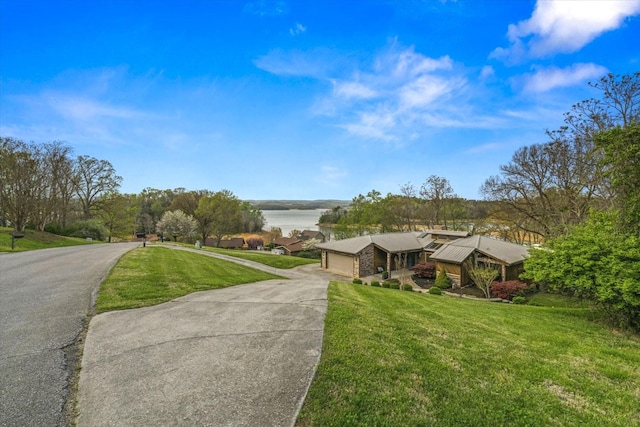 view of front of home featuring aphalt driveway, a garage, and a front lawn