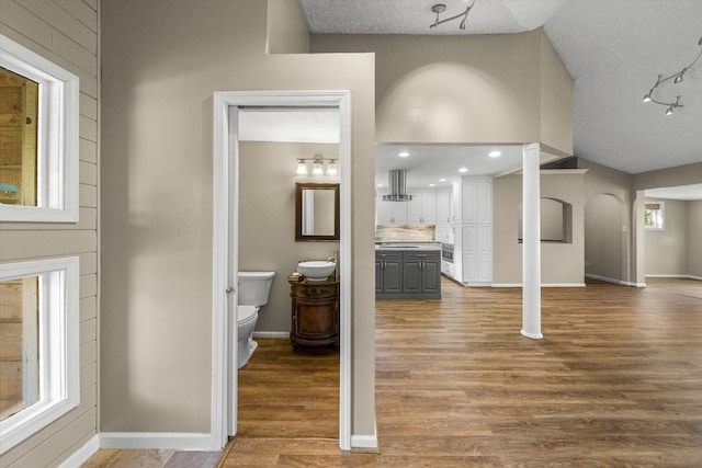 interior space featuring baseboards, wood finished floors, and a textured ceiling