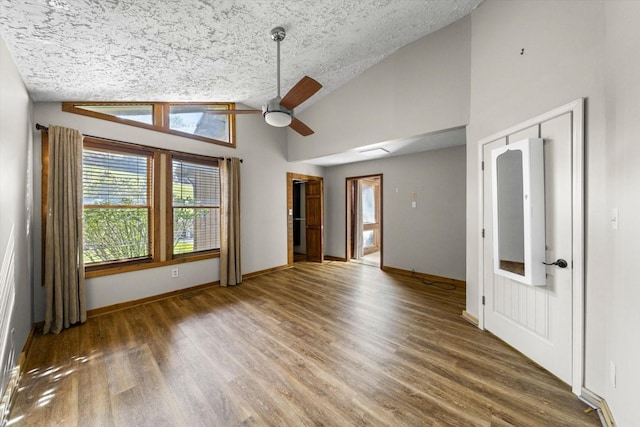 spare room with ceiling fan, a textured ceiling, wood finished floors, and baseboards
