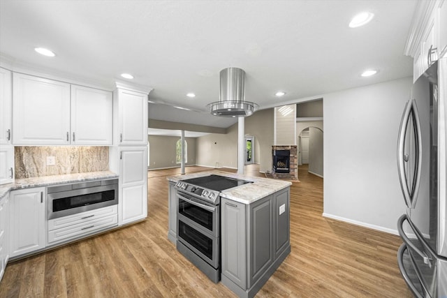 kitchen with gray cabinets, open floor plan, white cabinetry, stainless steel appliances, and light wood finished floors