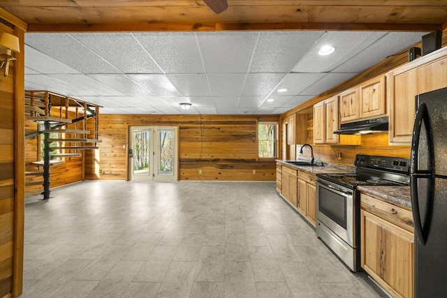 kitchen with freestanding refrigerator, under cabinet range hood, stainless steel electric stove, a healthy amount of sunlight, and a sink