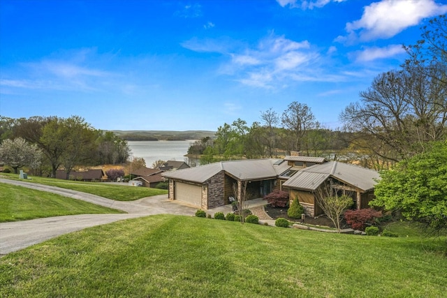 mid-century modern home with concrete driveway, stone siding, a front lawn, a garage, and metal roof