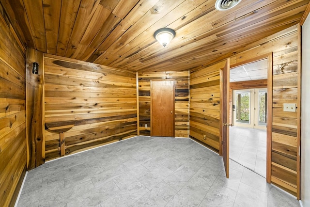 unfurnished room featuring wood walls and wooden ceiling