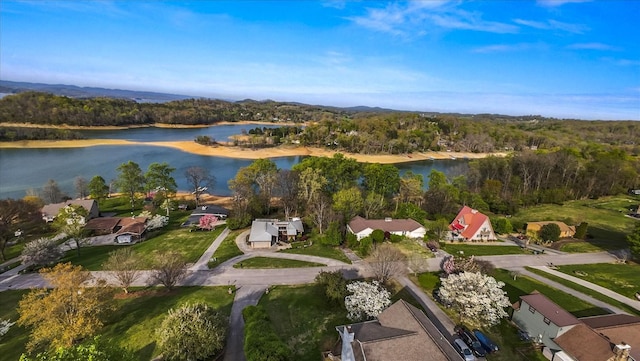 birds eye view of property with a water view and a wooded view