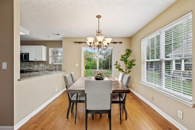 3227 Gardendale Dr, Franklin, TN 37064 - dining space featuring light wood-type flooring, a healthy amount of sunlight, baseboards, and a notable chandelier