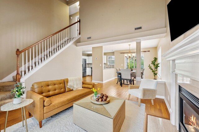 3227 Gardendale Dr, Franklin, TN 37064 - living area featuring hardwood / wood-style floors, a fireplace, a chandelier, and stairway