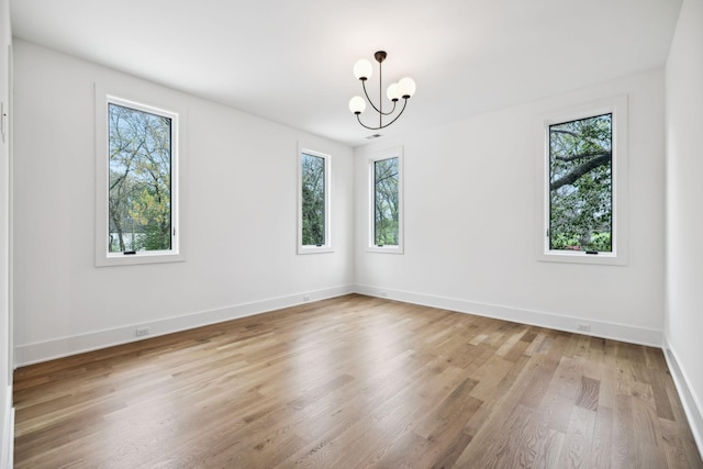 6004 Jocelyn Hollow Rd, Nashville, TN 37205 - empty room with a notable chandelier, light wood-type flooring, baseboards, and a healthy amount of sunlight