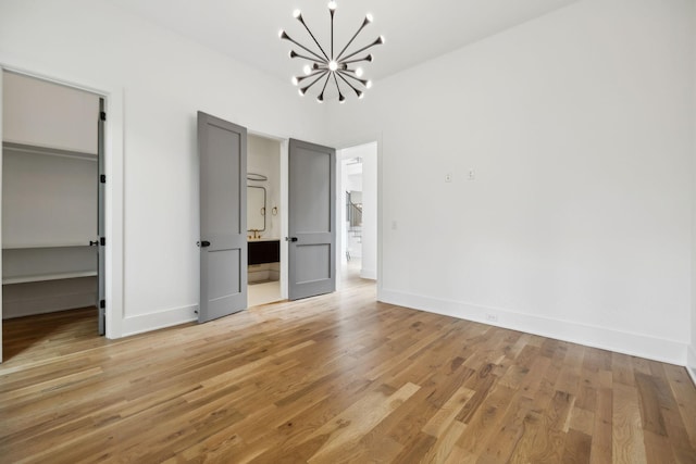 6004 Jocelyn Hollow Rd, Nashville, TN 37205 - unfurnished bedroom featuring a chandelier, light wood-type flooring, and a walk in closet