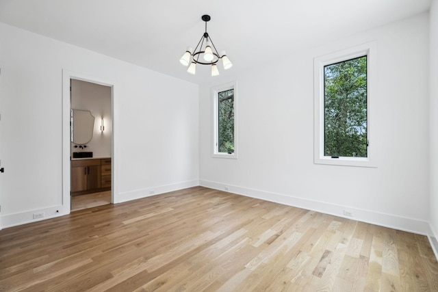 6004 Jocelyn Hollow Rd, Nashville, TN 37205 - unfurnished room with a chandelier, light wood-type flooring, and a healthy amount of sunlight