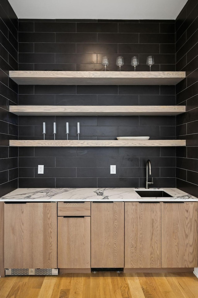 6004 Jocelyn Hollow Rd, Nashville, TN 37205 - bar with tasteful backsplash, light wood finished floors, and a sink