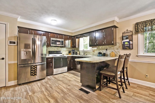 3115 Coon Hunter Lodge Rd, Jamestown, TN 38556 - kitchen with stainless steel appliances, a peninsula, light countertops, dark brown cabinets, and a sink
