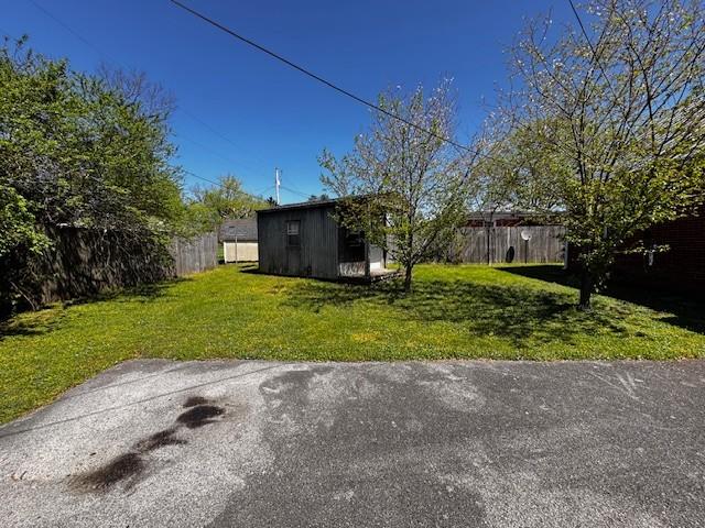 view of yard with fence and an outbuilding