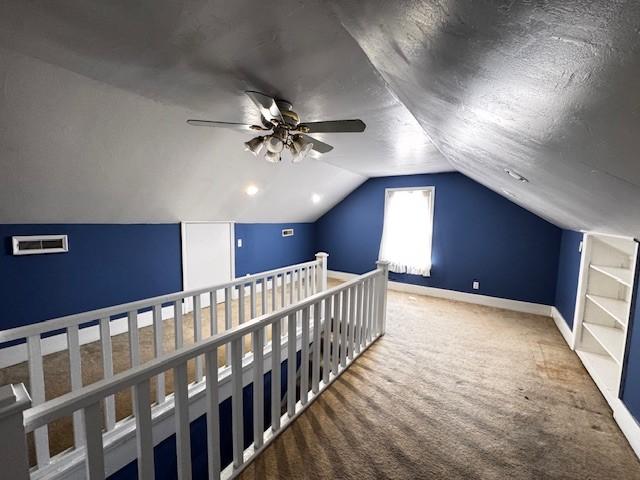 bonus room with baseboards, a ceiling fan, carpet, a textured ceiling, and vaulted ceiling