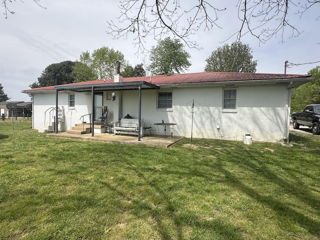 2901 Hurricane Creek Rd, Lawrenceburg, TN 38464 - back of property with brick siding, a lawn, a patio, and metal roof