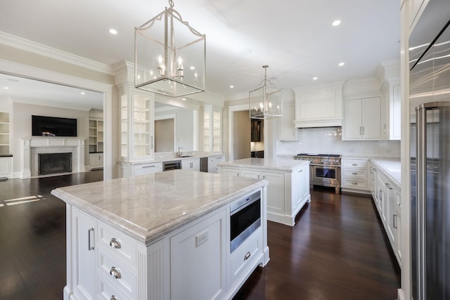 6021 Jocelyn Hollow Rd, Nashville, TN 37205 - kitchen featuring dark wood-style flooring, appliances with stainless steel finishes, premium range hood, crown molding, and a kitchen island