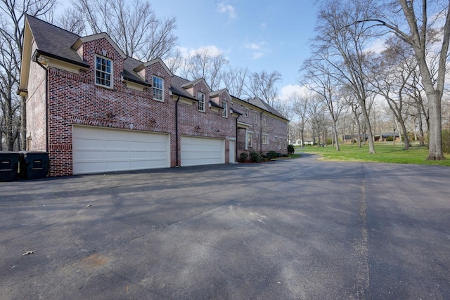 6021 Jocelyn Hollow Rd, Nashville, TN 37205 - view of side of home with a shingled roof, driveway, a garage, and brick siding
