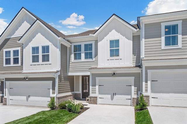 multi unit property with board and batten siding, an attached garage, and concrete driveway
