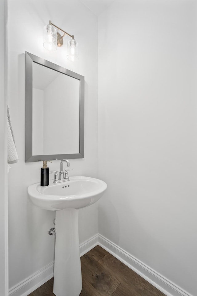 bathroom featuring wood finished floors, a sink, and baseboards