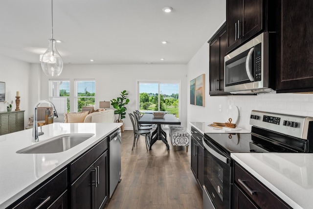 kitchen with dark wood finished floors, light countertops, a sink, and appliances with stainless steel finishes