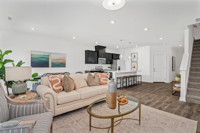 living area with recessed lighting, stairs, and dark wood finished floors