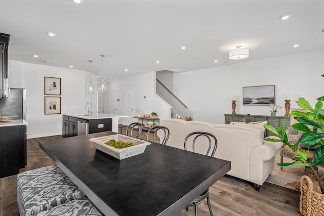 dining space with dark wood-style flooring, recessed lighting, and stairs