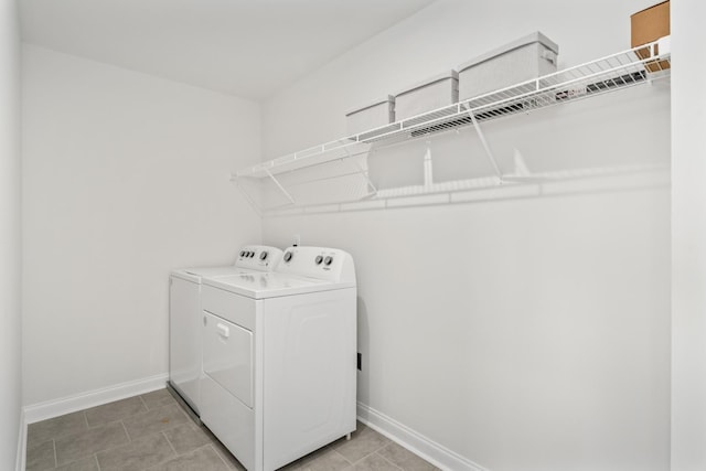 washroom with washing machine and dryer, laundry area, and baseboards