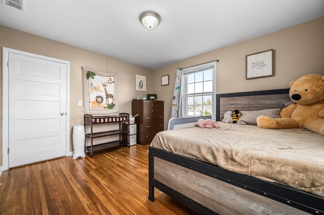 bedroom featuring wood finished floors and visible vents