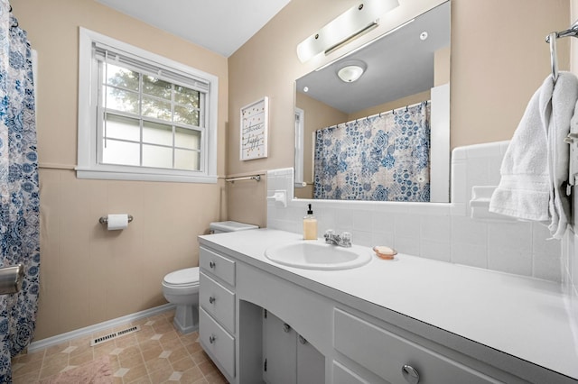 full bath featuring vanity, tile patterned flooring, toilet, visible vents, and wainscoting