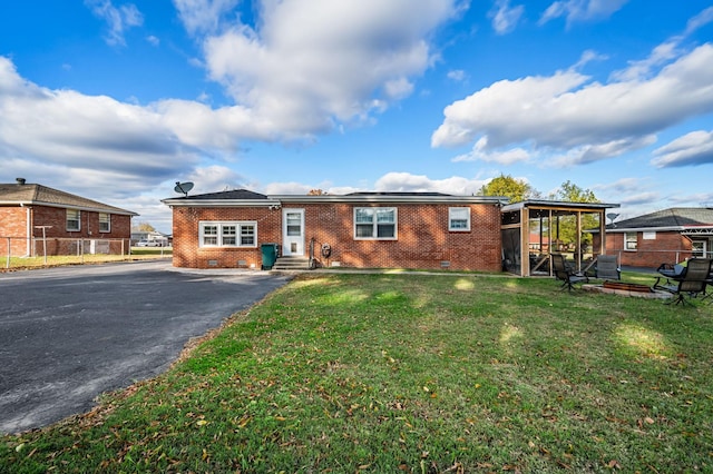 ranch-style home featuring crawl space, fence, a front lawn, brick siding, and driveway