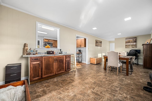 dining room featuring crown molding and baseboards