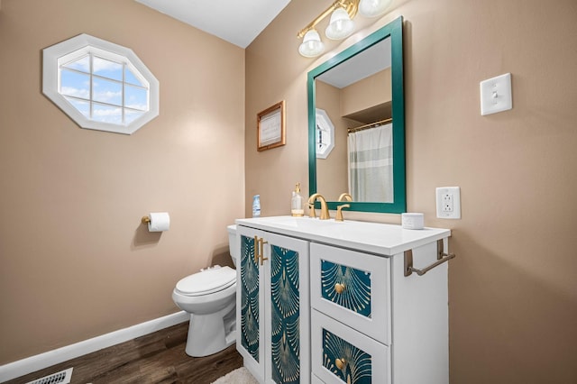 full bath featuring vanity, baseboards, toilet, and wood finished floors