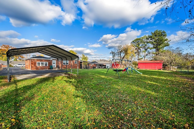 view of yard featuring fence, a detached carport, and a playground