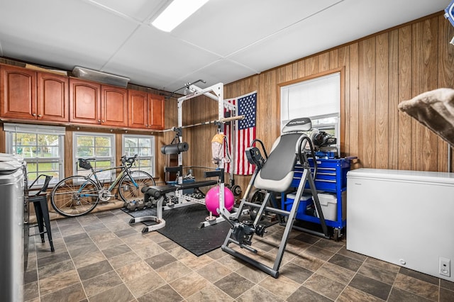 workout room featuring stone finish flooring and wooden walls
