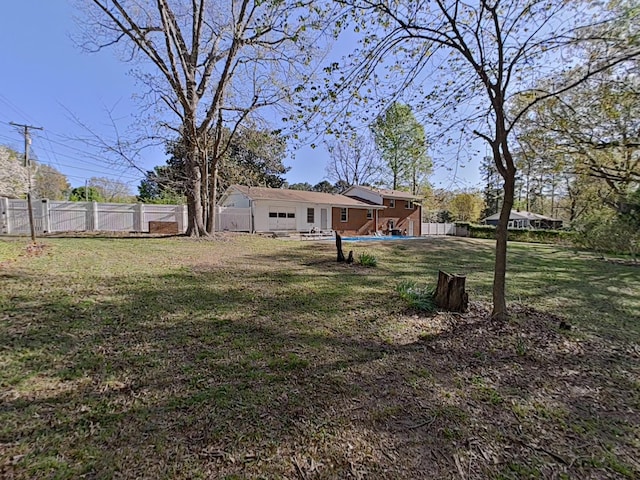 view of yard with a pool and a fenced backyard