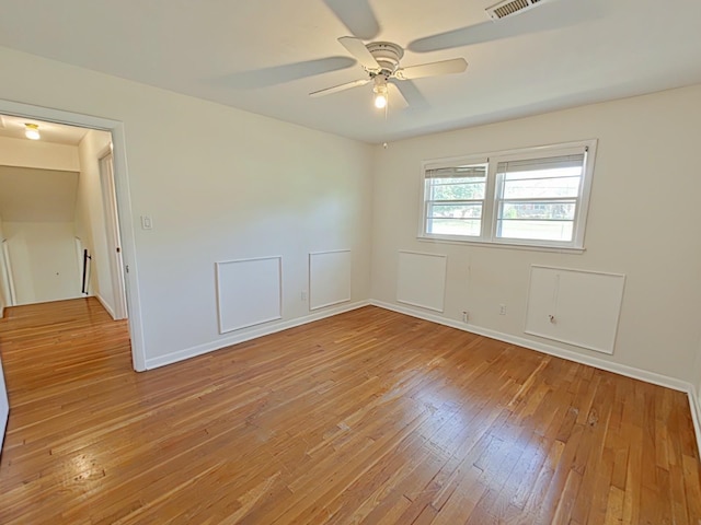 empty room with ceiling fan, light wood-type flooring, and baseboards