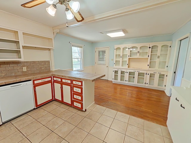 kitchen featuring open shelves, white dishwasher, a ceiling fan, a peninsula, and light tile patterned flooring