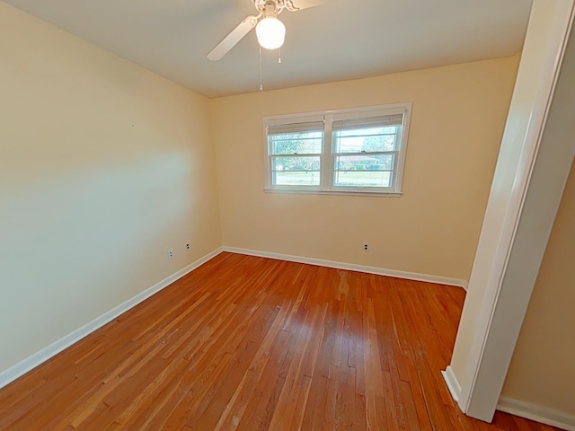 empty room featuring baseboards, ceiling fan, and hardwood / wood-style floors