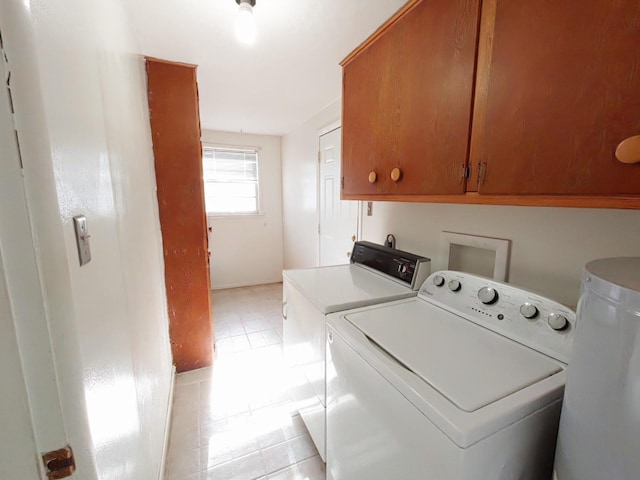clothes washing area featuring cabinet space, light tile patterned floors, and washer and dryer