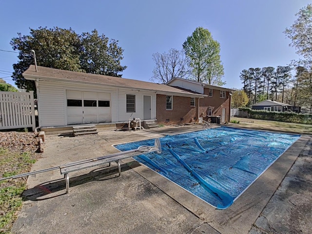 view of swimming pool with a patio, entry steps, a diving board, and fence
