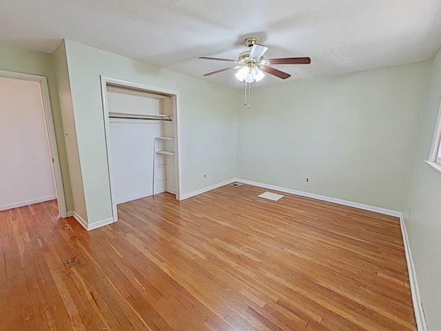 unfurnished bedroom featuring a closet, baseboards, light wood finished floors, and a ceiling fan
