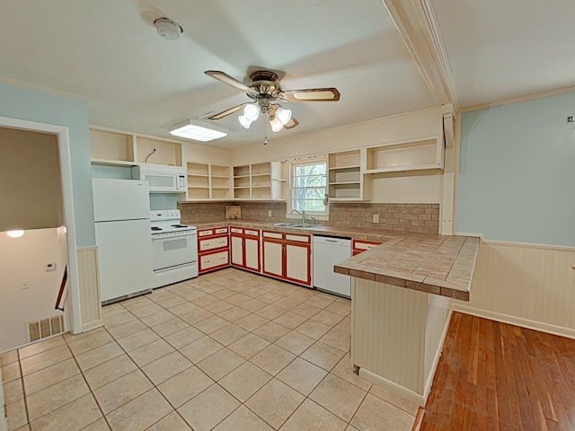 kitchen featuring white appliances, a ceiling fan, open shelves, a sink, and wainscoting