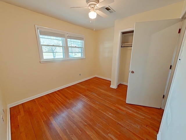 unfurnished bedroom with a closet, baseboards, a ceiling fan, visible vents, and light wood finished floors